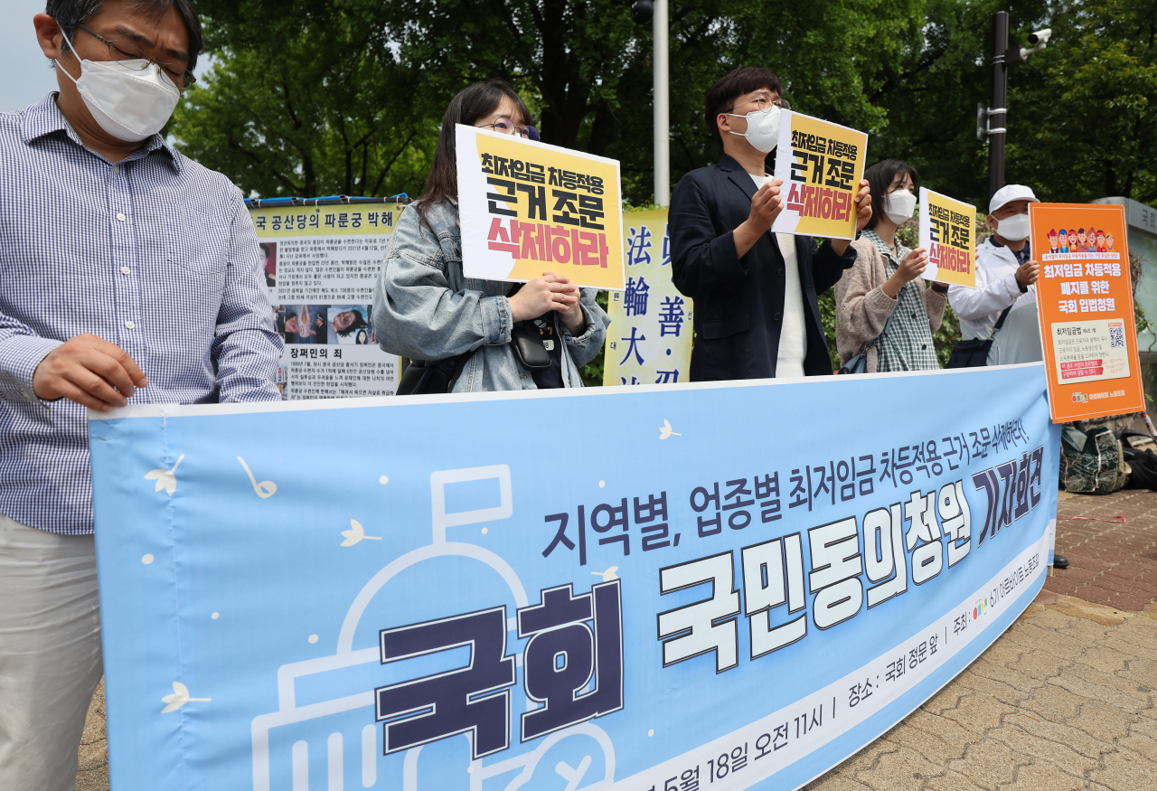 아르바이트 노동조합 관계자들이 18일 오전 서울 국회 앞에서 '지역별, 업종별 최저임금 차등적용 근거 조문 삭제를 위한 국회 국민동의청원 기자회견'을 하고 있다. [연합]