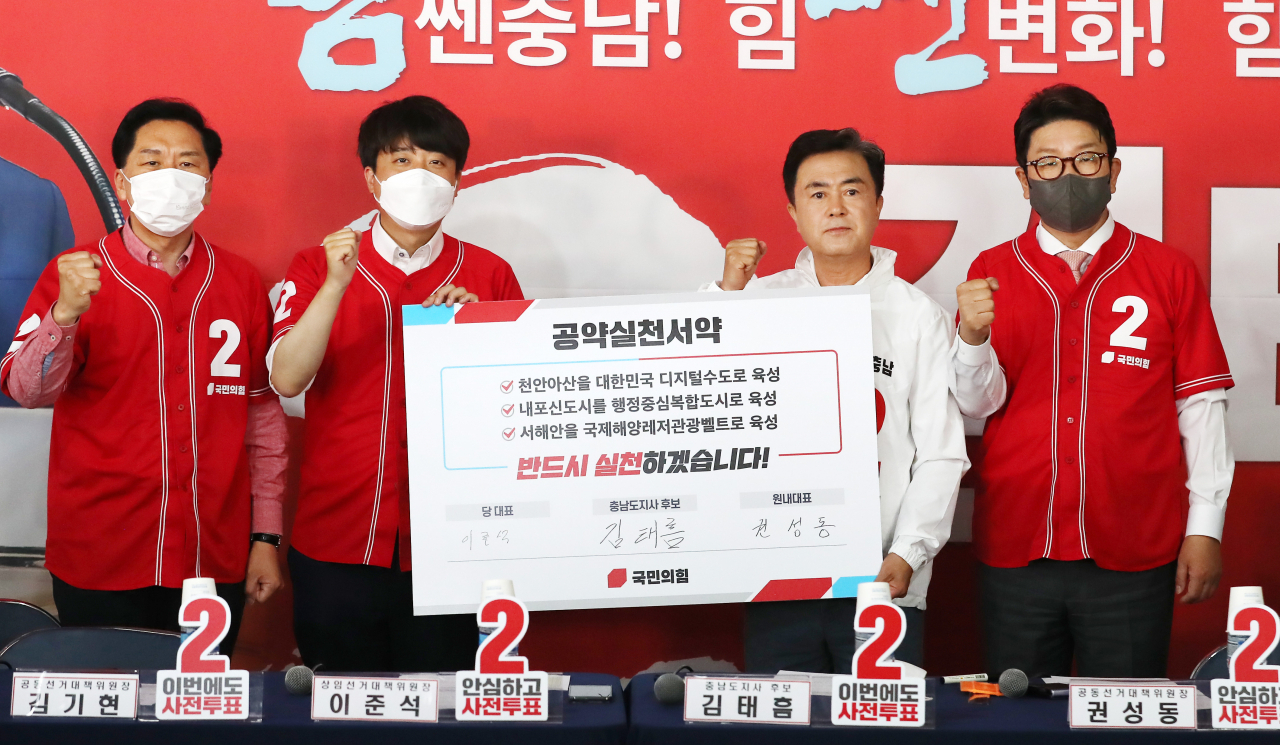 25일 오전 충남 천안시 불당동 김태흠 충남지사 후보 선거사무소에서 열린 중앙선거대책위원회 현장 회의 시작 전 참석자들이 공약 실천 서약서를 들고 기념사진을 찍고 있다. 왼쪽부터 김기현 공동선거대책위원장, 이준석 상임선거대책위원장, 김태흠 충남지사 후보, 권성동 공동선거대책위원장. [연합]