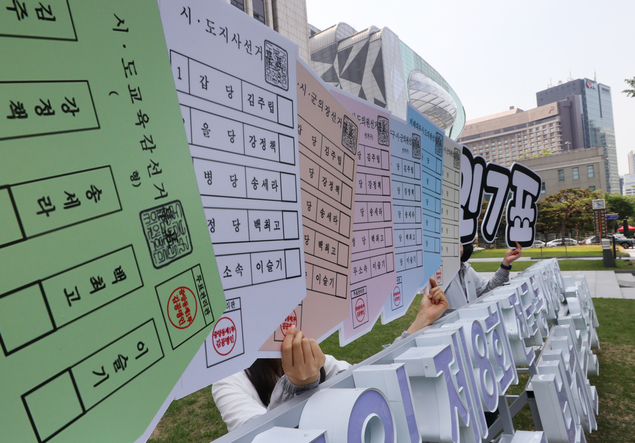 20일 오전 서울시선거관리위원회 직원들이 서울 중구 프레스센터 앞에서 6.1 지방선거 홍보행사를하며 투표용지 7장이 그려진 팻말을 들고 있다. 6.1 지방선거 유권자들은 광역단체장, 교육감, 기초단체장(자치구·시·군의 장), 지역구 광역의원, 지역구 기초의원, 비례대표 광역의원, 비례대표 기초의원 총 7장의 투표용지를 받게 된다. [연합]