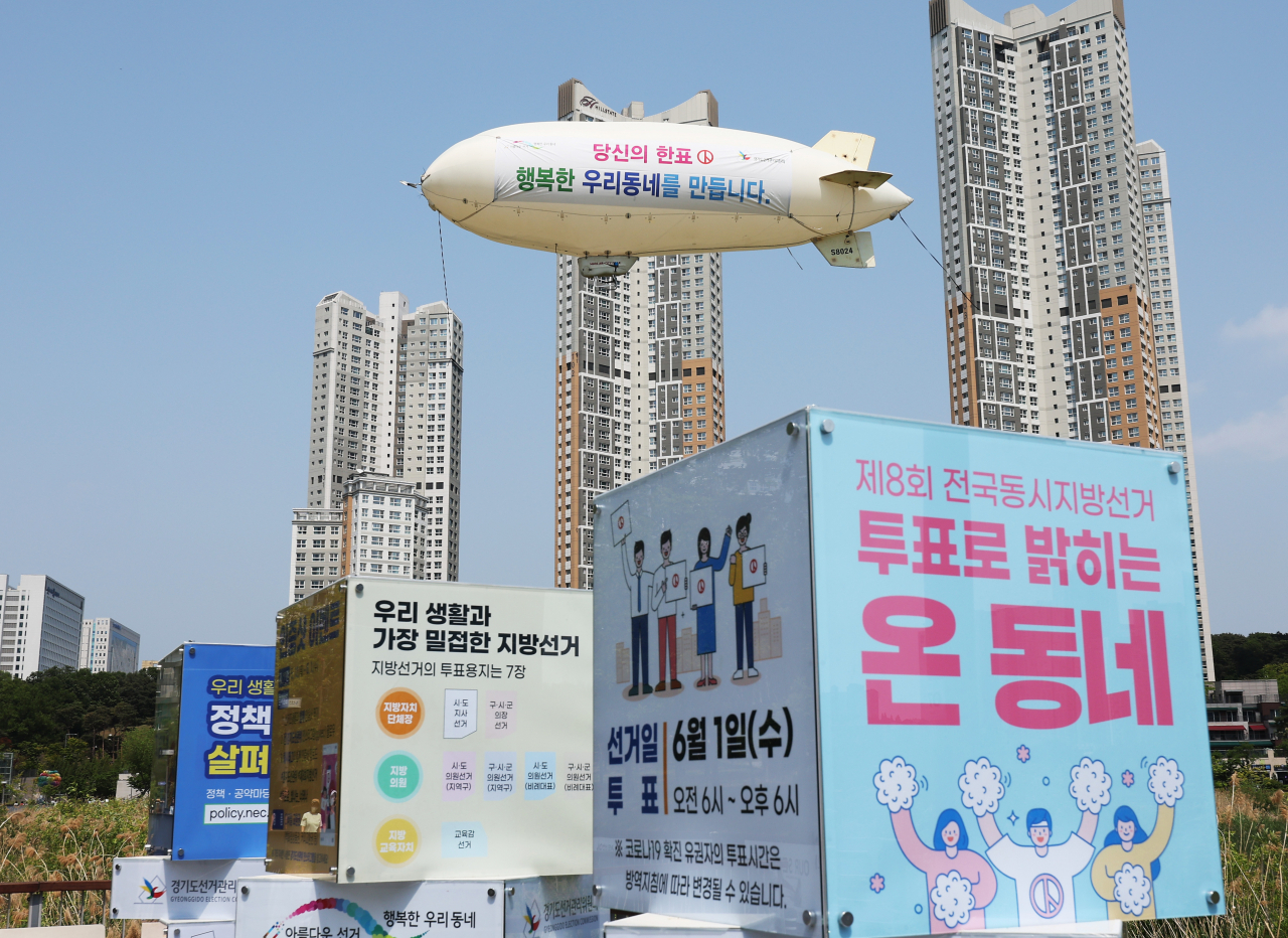 경기도 수원시 광교호수공원에서 경기도선거관리위원회 관계자들이 비행선을 이용한 제8회 전국동시지방선거 투표 참여 캠페인을 하고 있다. [연합]