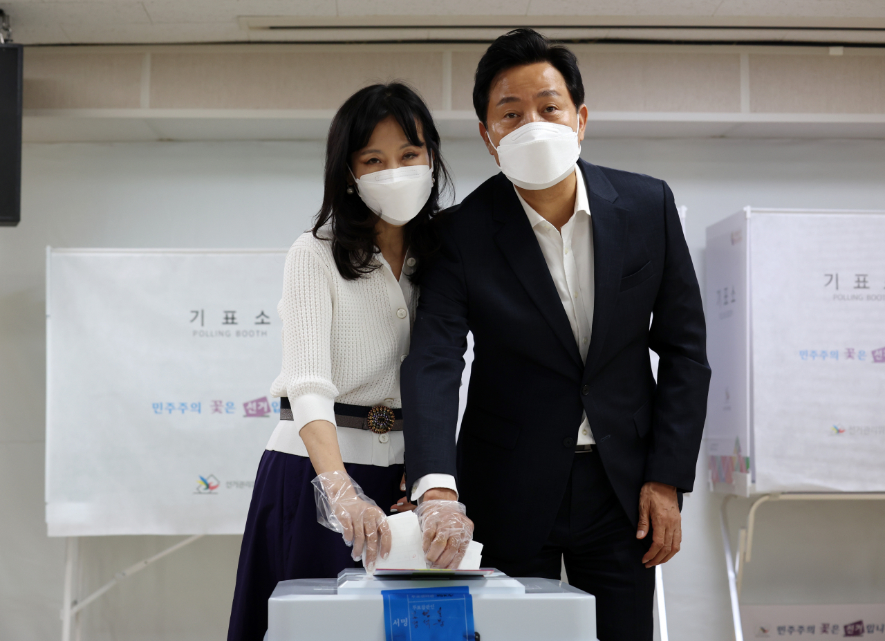 오세훈 국민의힘 서울시장 후보와 부인 송현옥 씨가 제8회 전국동시지방선거 사전투표 첫날인 27일 서울 광진구 자양3동 주민센터에 마련된 사전투표소에서 투표하고 있다. [연합]