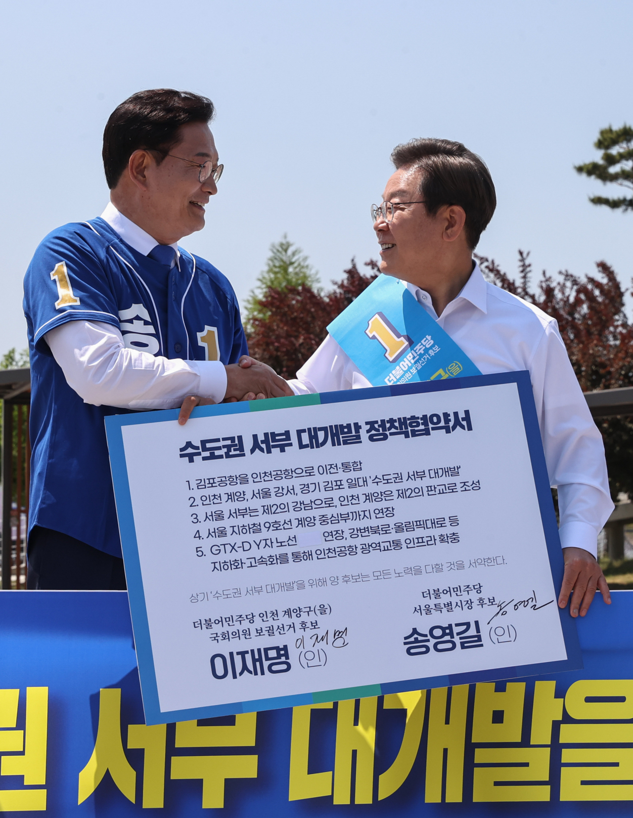 더불어민주당 송영길(왼쪽) 서울시장 후보와 이재명 인천 계양을 국회의원 후보가 27일 경기도 김포시 고촌읍 아라 김포여객터미널 아라마린센터 앞 수변광장에서 열린 김포공항 이전 수도권 서부 대개발 정책협약식에서 기념촬영을 하고 있다. [연합]