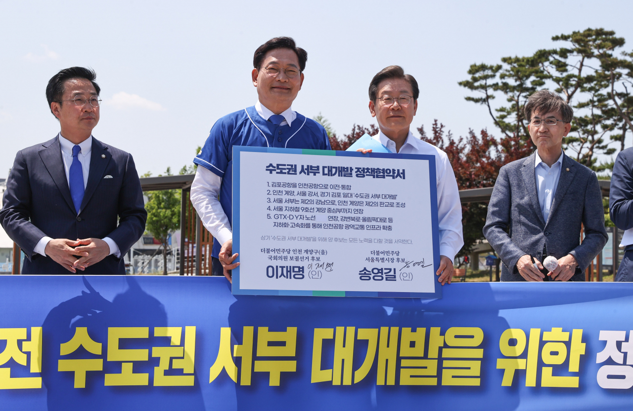 송영길 더불어민주당 서울시장 후보와 이재명 인천 계양을 국회의원 후보가 지난 27일 경기도 김포시 고촌읍 아라 김포여객터미널 아라마린센터 앞 수변광장에서 열린 김포공항 이전 수도권 서부 대개발 정책협약식에서 기념촬영을 하고 있다. [연합]