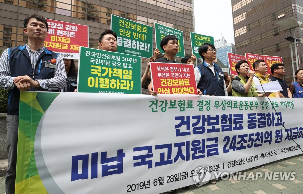 무상의료운동본부 관계자들이 28일 건강보험정책심의위원회가 열린 서울 서초구 건강보험심사평가원 앞에서 건강보험료 동결과 미납 국고지원금 지급 등을 촉구하는 기자회견을 하고 있다. [연합]