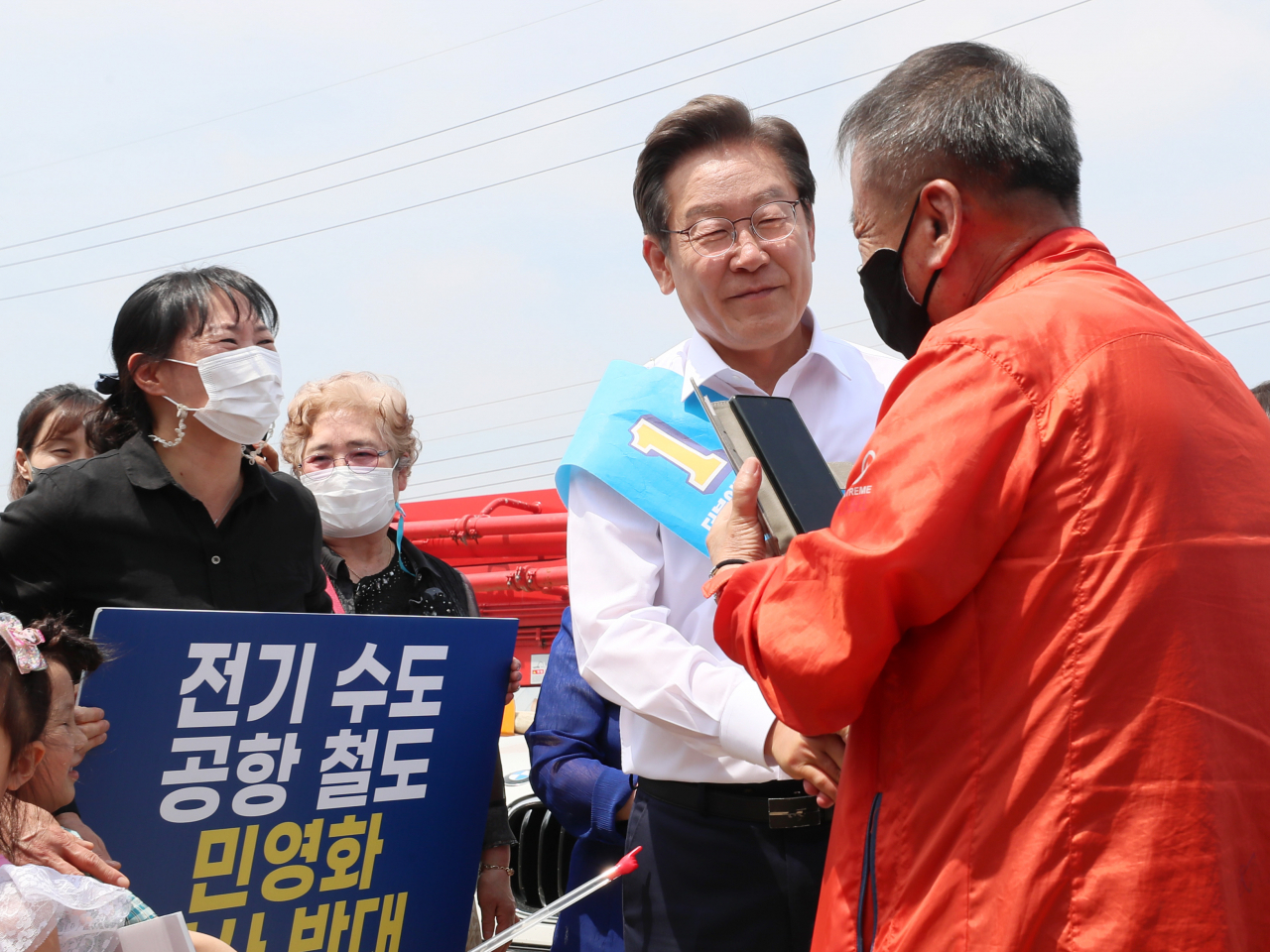 더불어민주당 이재명 인천 계양을 국회의원 보궐선거 후보가 29일 인천 계양구 김포도시철도 기지창 인근에서 '지하철 9호선 계양 연장 공약'을 발표한 뒤 지지자들과 인사하고 있다. [연합]