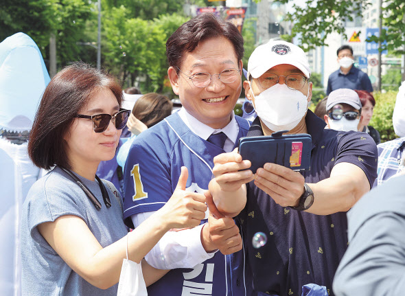 코 앞으로 다가온 6·1 지방선거룰 앞두고 오세훈 국민의힘 서울시장 후보와 송영길 더불어민주당 서울시장 후보가 표심 잡기에 총력을 기울이고 있다. 오세훈 후보가 29일 서울 마포구 연남동 경의선숲길을 돌며 유권자에게 손을 들어 인사를 하고 있다(위쪽 사진). 송영길 후보도 같은 날 서울 강북구 북서울꿈의숲에서 열린 유세에서 시민과 기념촬영을 하고 있다. [연합]