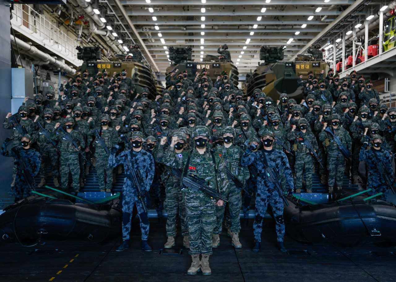 해군 환태평양훈련전단은 31일 다국적 해상훈련인 2022 환태평양훈련 림팩(RIMPAC) 참가를 위해 31일 오전 제주해군기지에서 출항했다. 마라도함(LPH·1만4500t급)에 편승해 출항하는 해병중대장 김윤호 대위(가운데 맨 앞)를 비롯한 130여명의 해병대 대원들이 마라도함 차량갑판에서 임무 완수 각오를 다짐하고 있다. [해군 제공]
