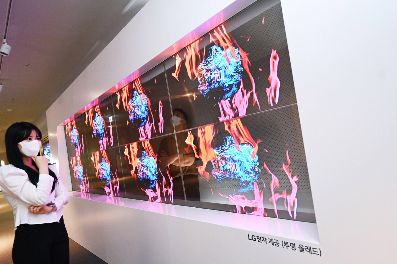LG전자 모델이 동대문디자인플라자에 설치된 투명 올레드 사이니지를 통해 국내 미디어 아티스트 장서원 작가의 작품을 감상하고 있다.[LG전자 제공]