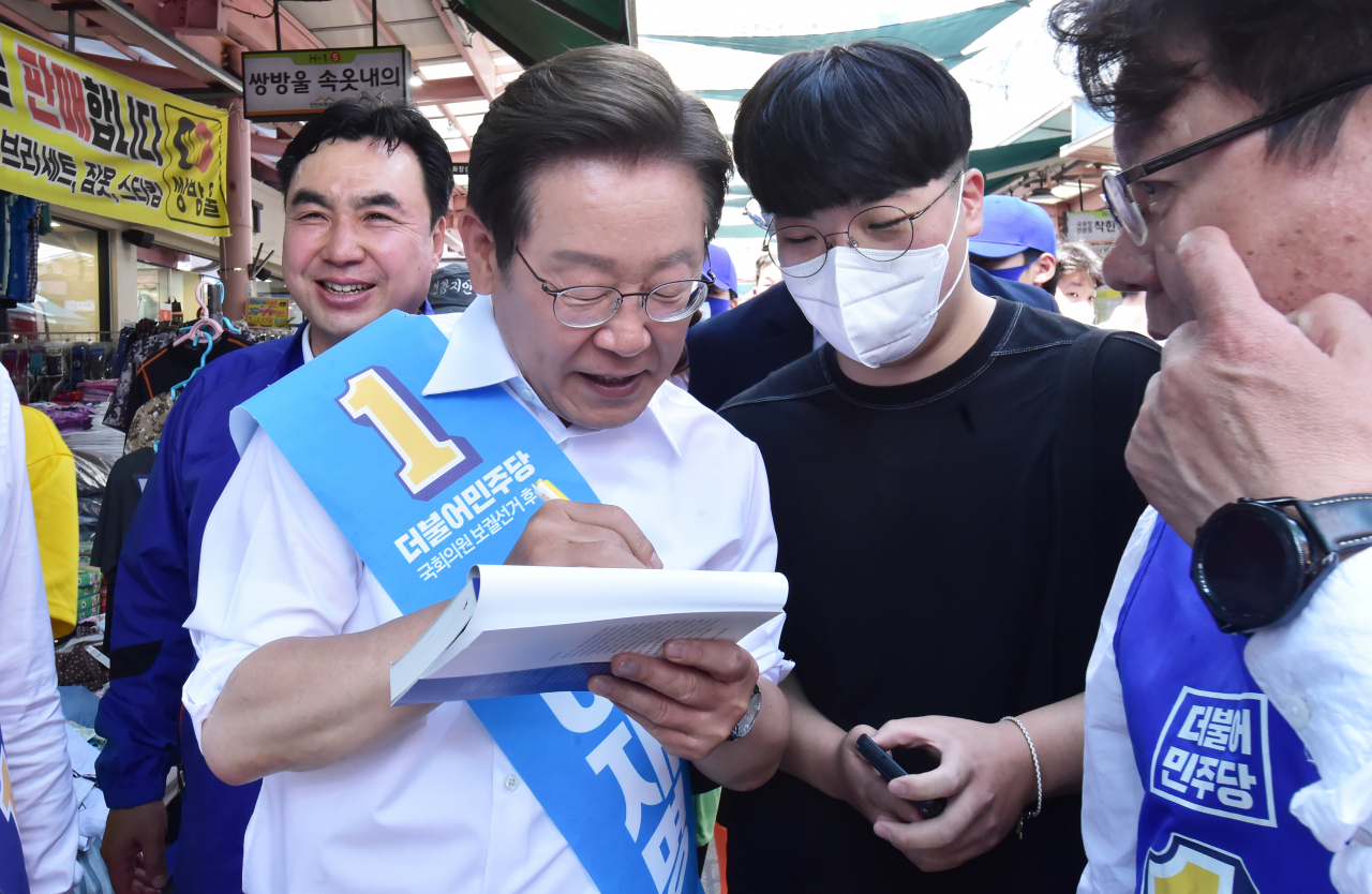 더불어민주당 이재명 총괄선대위원장이 31일 인천시 남동구 모래내 시장을 방문해 한 시민에게 사인을 해주고 있다. [연합]