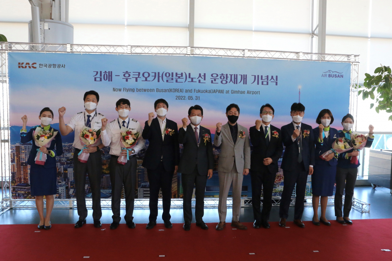 안병석 에어부산 대표(왼쪽 5번째)와 윤형중 한국공항공사 사장(왼쪽 6번째), 그리고 마루야마 코헤이 주부산 일본국 총영사(오른쪽 4번째)를 비롯한 관계 기관 관계자들이 부산-후쿠오카 운항 재개를 기념해 사진 촬영을 하고 있다. [에어부산 제공]