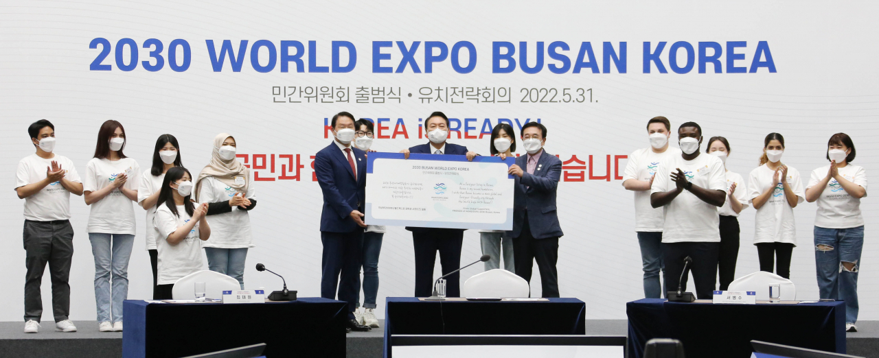 윤석열 대통령(가운데), 최태원 대한상의 회장(왼쪽), 서병수 국회 2030부산세계박람회 유치지원특위 위원장(오른쪽)이 엑스포 유치치기원보드를 들고 청년 서포터즈들과 기념촬영을 하고 있다. [상의 제공]