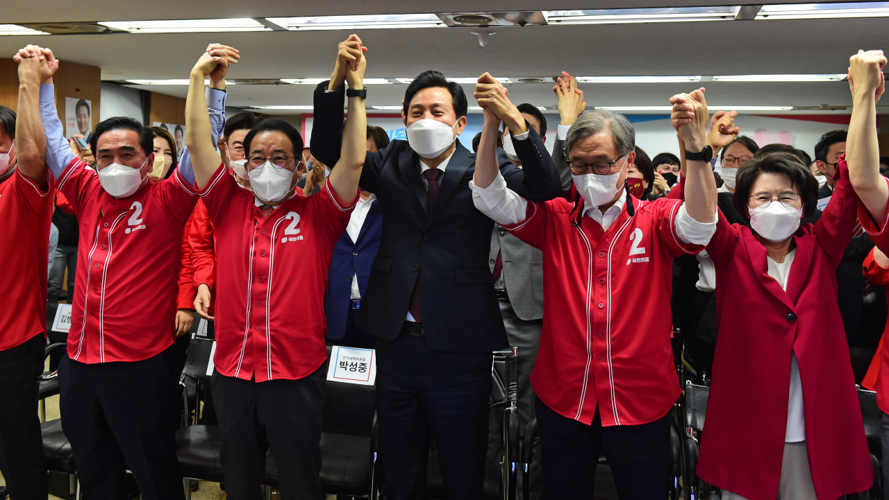 오세훈 국민의힘 서울시장 후보가 1일 서울 중구 프레스센터에 마련된 캠프 개표상황실에서 출구조사 결과발표를 시청하며 기뻐하고 있다. [연합]