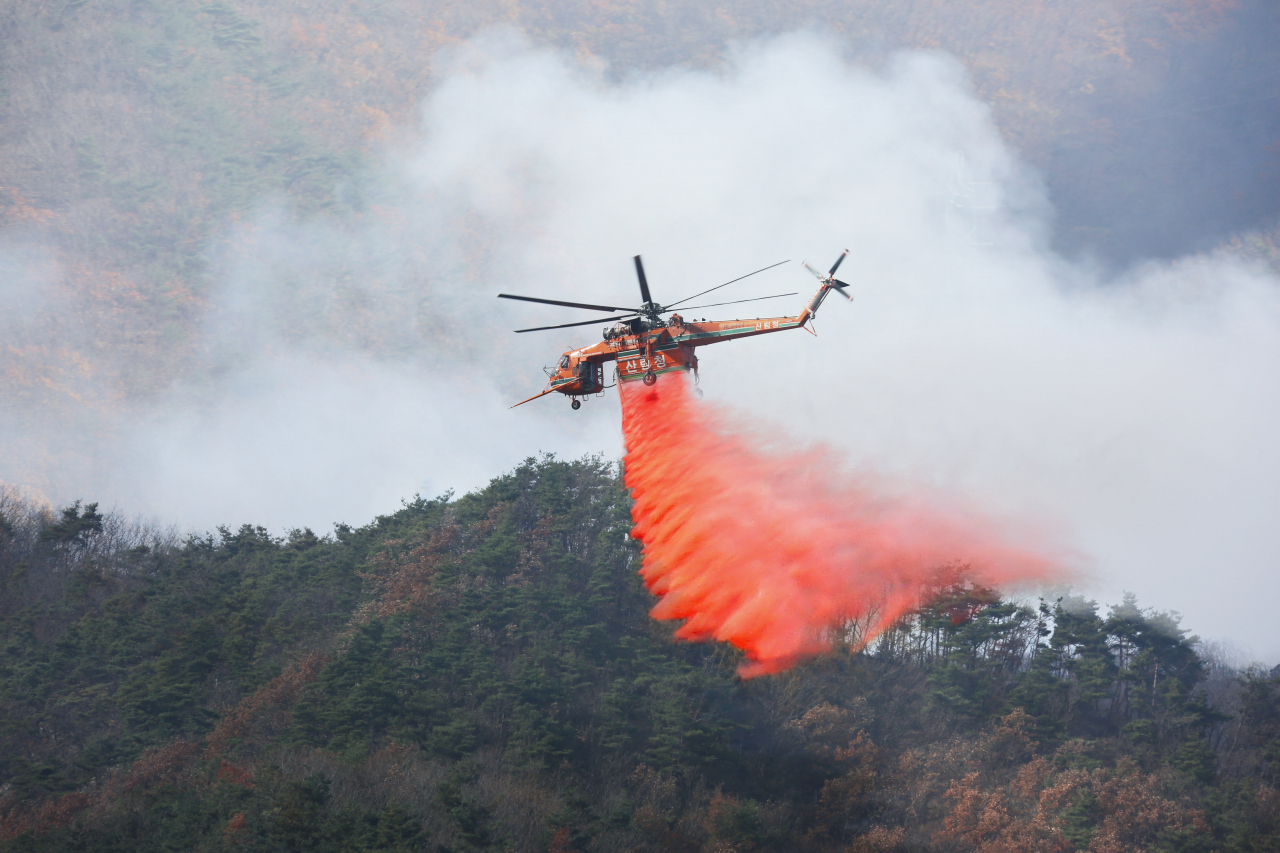 1일 오전 경남 밀양시 부북면 산불 현장에서 산불진화헬기가 산불지연제(리타던트)를 뿌리며 산불을 진화하고 있다. [연합]