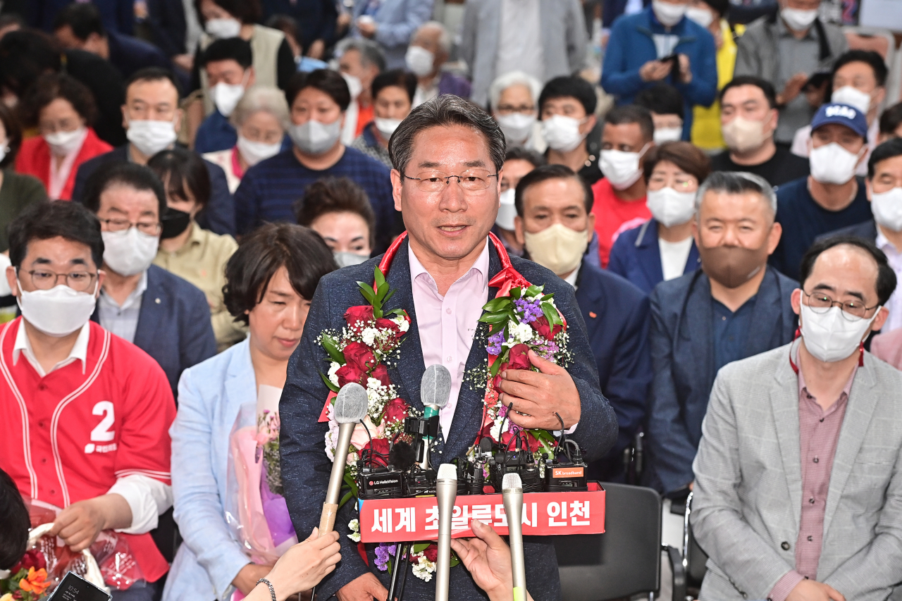 6·1 지방선거가 시행된 1일 오후 국민의힘 유정복 인천시장 후보가 득표율에서 경쟁자 더불어민주당 박남춘 후보를 크게 앞서자 인천시 미추홀구 자신의 선거사무소에서 꽃목걸이를 받고 방송사 인터뷰를 하고 있다. [연합]