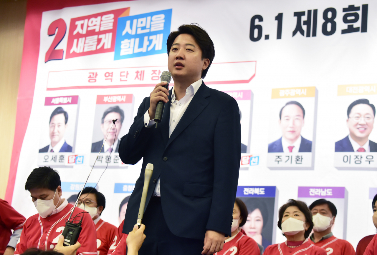 국민의힘 이준석 대표가 1일 오후 국회 도서관 대강당에 마련된 지방선거 개표상황실에서 당선이 유력시되는 단체장 후보 사진 밑에 스티커를 붙인 뒤 소감을 밝히고 있다. [연합]