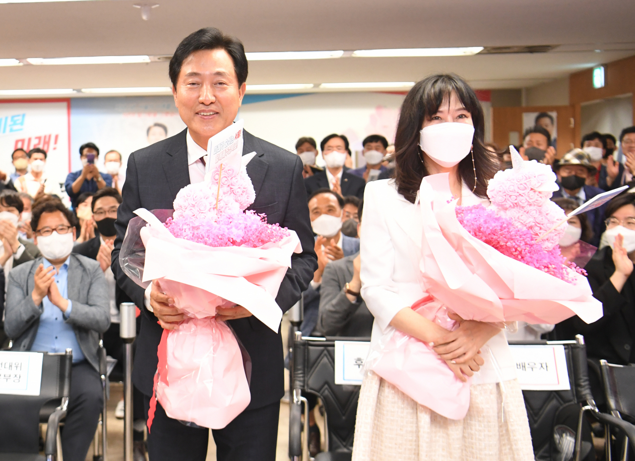 오세훈 국민의힘 서울시장 당선인이 2일 서울 중구 프레스센터에 마련된 선거캠프 개표상황실에서 당선이 확정되자 부인 송현옥 씨와 함께 꽃다발을 받고 있다. [연합]