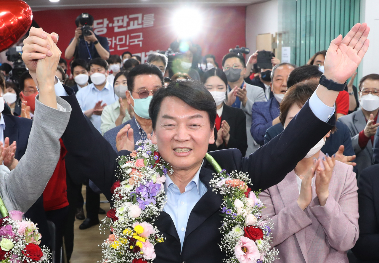 경기 성남 분당갑 국회의원 보궐선거에 출마한 안철수 국민의힘 후보가 1일 오후 당선이 확실시 되자 분당 선거사무소에서 꽃을 받아들고 세리머니를 하고 있다. [연합]