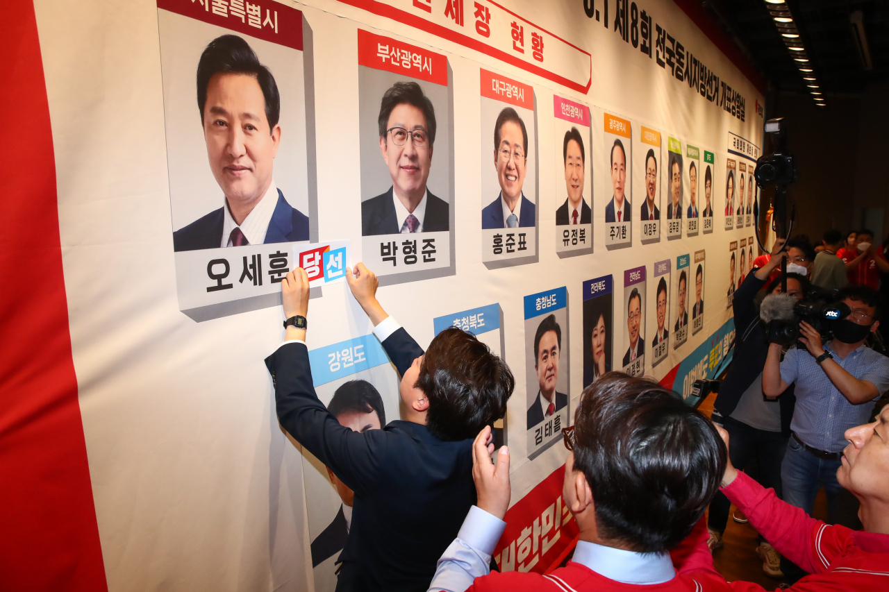 국민의힘 이준석 대표와 지도부가 1일 오후 국회 도서관 대강당에 마련된 지방선거 개표상황실에서 당선이 유력시되는 단체장 후보 사진 밑에 스티커를 붙이는 세리모니를 하고 있다. [연합]