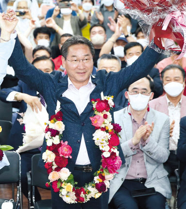 유정복 국민의힘 당선인이 민선8기 인천시장에 당선이 확정되자 축하 꽃목걸이를 한채 두손을 높이 들며 기뻐하고 있다. [유정복 국민의힘 인천시장 선거캠프 제공]