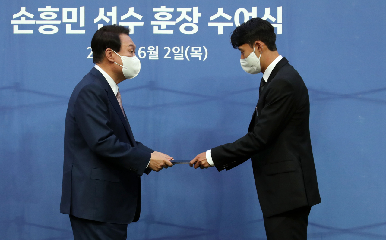 윤석열 대통령이 2일 오후 서울 마포구 서울월드컵경기장에서 아시아 선수 최초로 잉글랜드 프로축구 프리미어리그 득점왕에 오른 손흥민 선수에게 체육훈장 가운데 최고 등급인 청룡장을 수여하고 있다. 연합뉴스