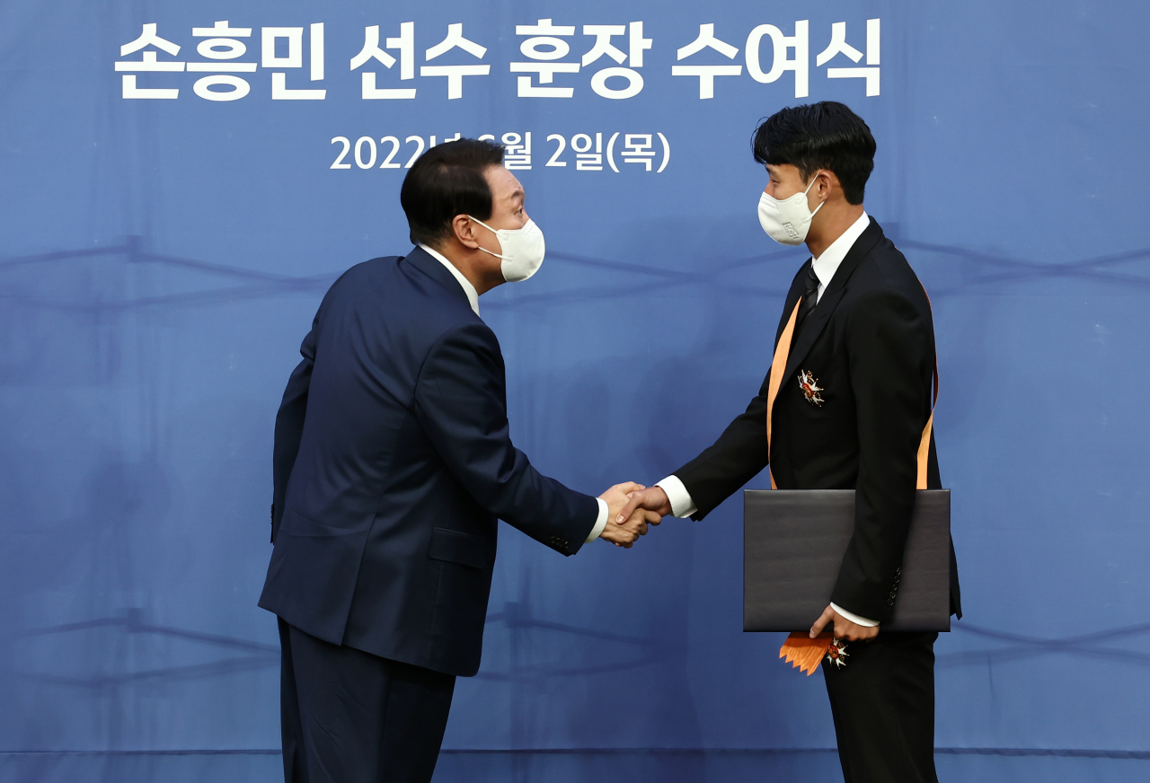 윤석열 대통령이 2일 오후 서울월드컵경기장에서 아시아 선수 최초로 잉글랜드 프로축구 프리미어리그 득점왕에 오른 손흥민에게 체육훈장 가운데 최고 등급인 청룡장을 수여하고 있다. [연합]