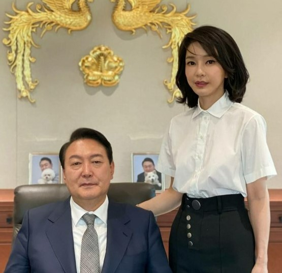 윤석열 대통령과 김건희 여사가 대통령실 집무실에서 대통령 표장을 배경으로 촬영한 사진이 30일 공개됐다. 윤 대통령 뒤로는 반려견 토리, 써니와 함께 찍은 윤 대통령의 사진이 놓여 있다. [연합]