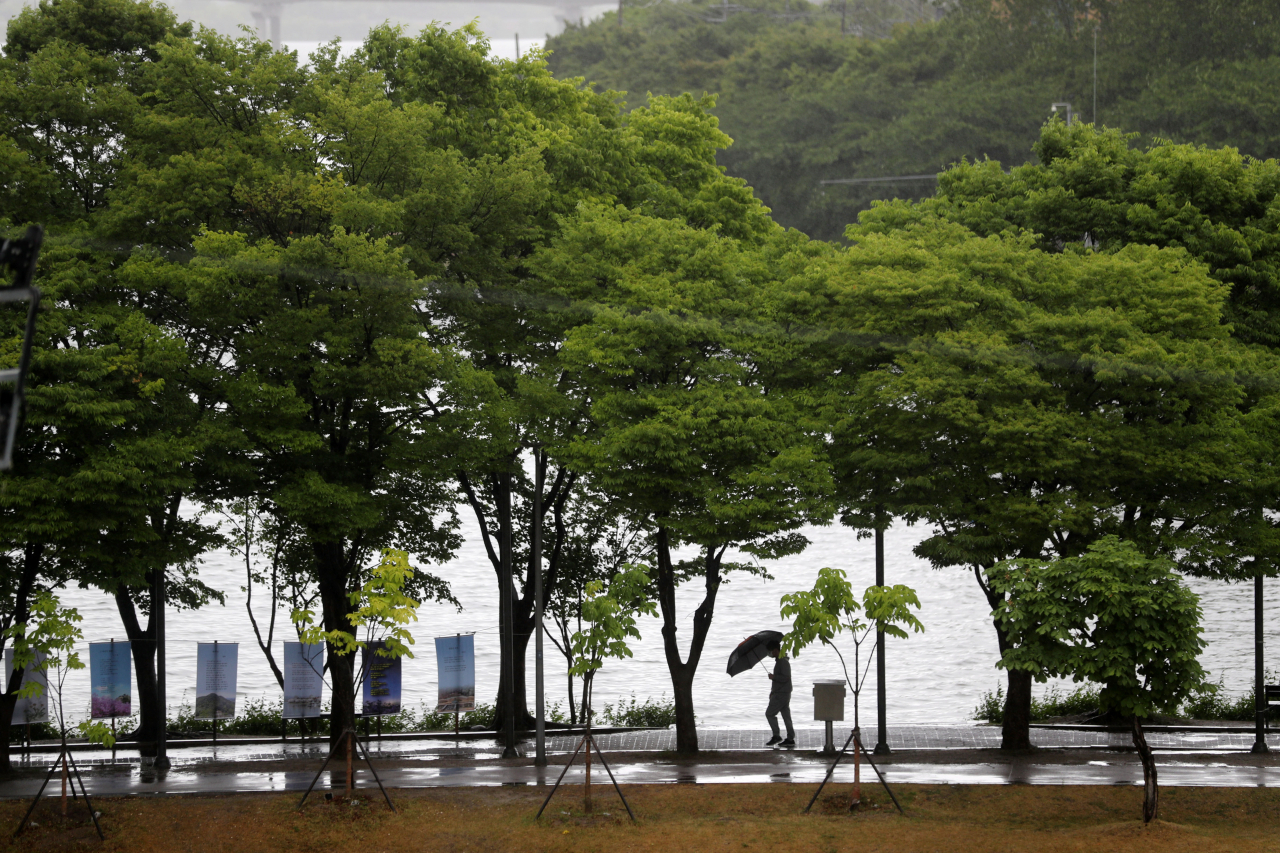현충일인 6일 오전 강원 춘천시 공지천 산책로에서 우산을 쓴 시민이 아침 산책을 하고 있다. 기사와 사진은 무관. [연합]