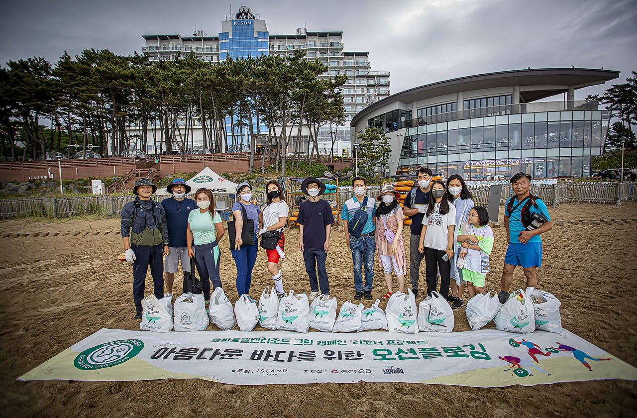 플로깅 성과물들을 펴놓고 기념촬영을 하고 있는 선셋플로깅 참가자들