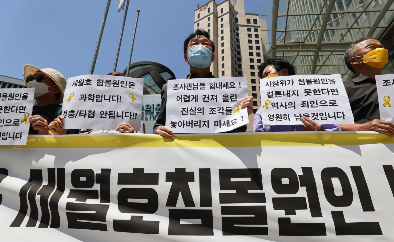 1일 오후 서울 중구 포스트타워 앞에서 열린 사회적 참사 특별조사위원회(사참위) 세월호 침몰 원인 결론 촉구 기자회견에서 참가자들이 팻말을 들고 있다. [연합]