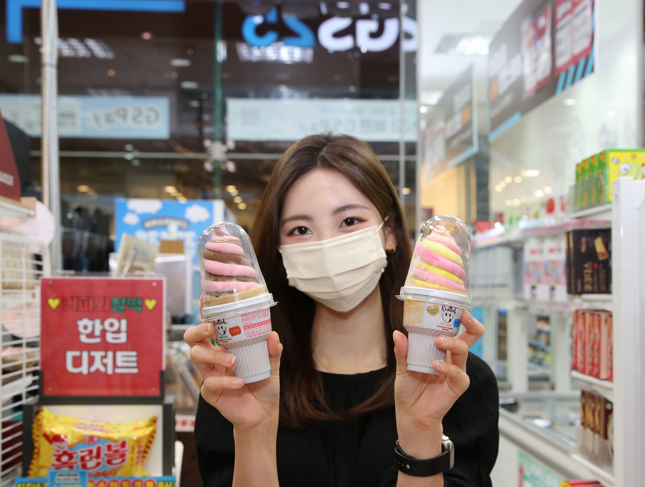 GS25에서 모델이 노티드소프트콘 2종상품을 들고 포즈를 취하고 있다. [GS25 제공]