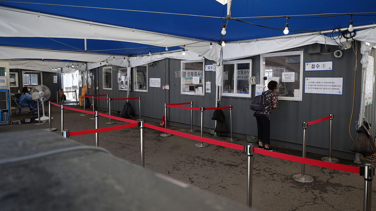 A citizen undergoes a COVID-19 test at a makeshift testing station in Seoul on Monday. (Yonhap)