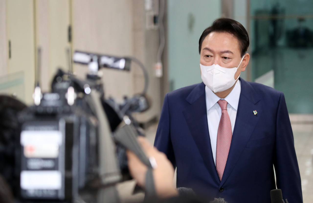President Yoon Suk-yeol takes reporters' questions as he arrives at the presidential office in Seoul on Thursday. (Yonhap)