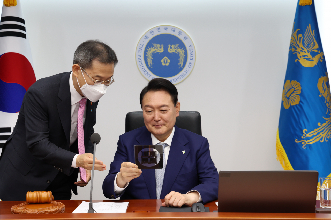 윤석열 대통령이 지난 7일 서울 용산 대통령실 청사에서 열린 국무회의에서 이종호 과학기술정보통신부 장관과 반도체 포토마스크를 살펴보고 있다. [연합]