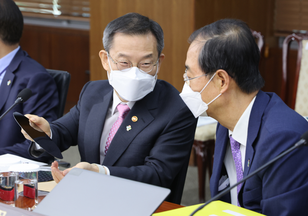 한덕수 국무총리(오른쪽)가 지난 7일 오전 서울 용산 대통령실 청사에서 열린 국무회의에 앞서 이종호 과학기술정보통신부 장관으로부터 반도체 웨이퍼에 대해 설명을 듣고 있다. [연합]