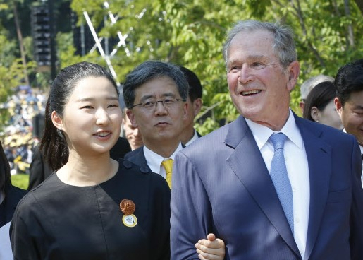 2019년 5월 23일 경남 김해시 진영읍 봉하마을에서 열린 고(故) 노무현 전 대통령 10주기 추모식에 참석한 노 전 대통령의 손녀 노서은 씨가 조지 W. 부시 전 미국 대통령과 팔짱을 낀 채 이동하고 있다. [노무현재단]