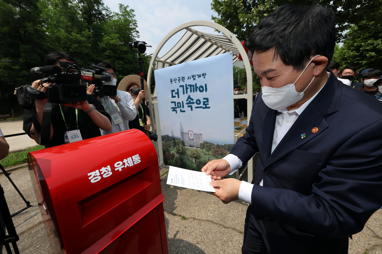 대통령 집무실 인근의 용산공원 부지가 일반 국민에게 시범 개방된 10일 원희룡 국토교통부 장관이 서울 용산공원에 설치된 경청우체통에 메시지를 적은 종이를 넣고 있다. [연합]