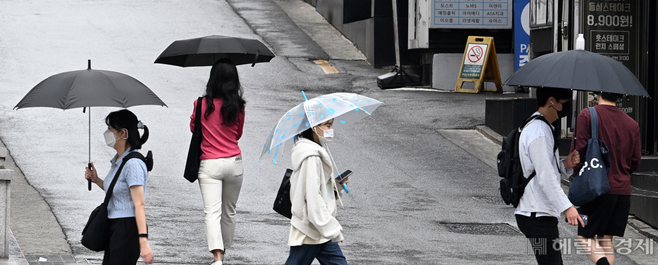 9일 서울 강남구 강남역 인근 거리에서 시민들이 소나기를 피해 우산을 쓰고 거리를 지나고 있다. [임세준 기자]