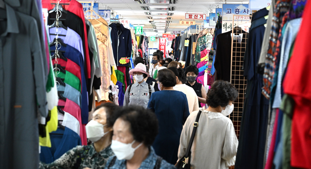 Shoppers browsing racks of clothing at Pyoung Hwa Fashion Plaza wholesale market in Dongdaemun Jung-gu Seoul