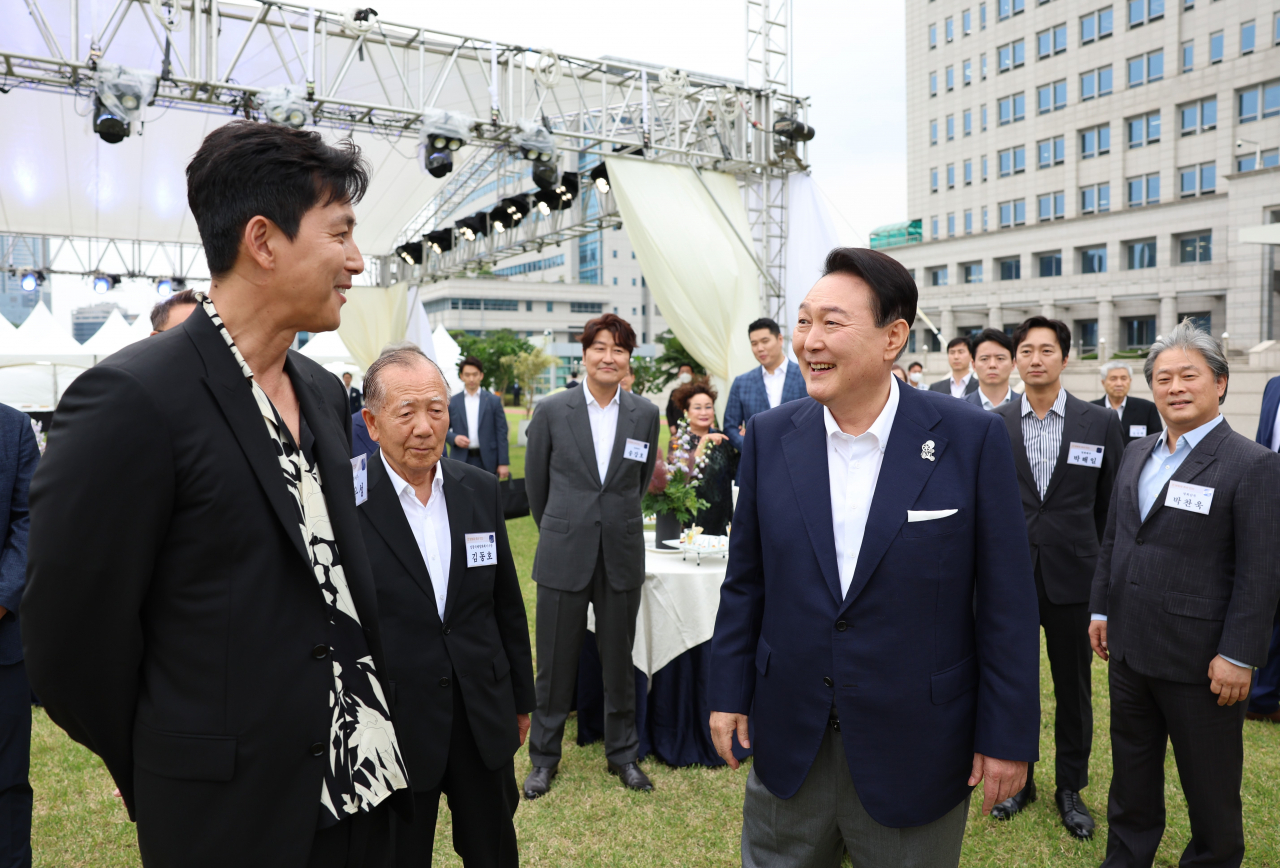 윤석열 대통령이 12일 오후 서울 용산 대통령실 청사 잔디마당에서 열린 영화관계자 초청 만찬에서 배우 정우성과 대화하고 있다. 이날 만찬에는 한국 배우 최초로 칸국제영화제에서 남우주연상을 받은 배우 송강호와 감독상을 수상한 박찬욱 감독(영화 헤어질 결심)등이 참석했다. [연합]