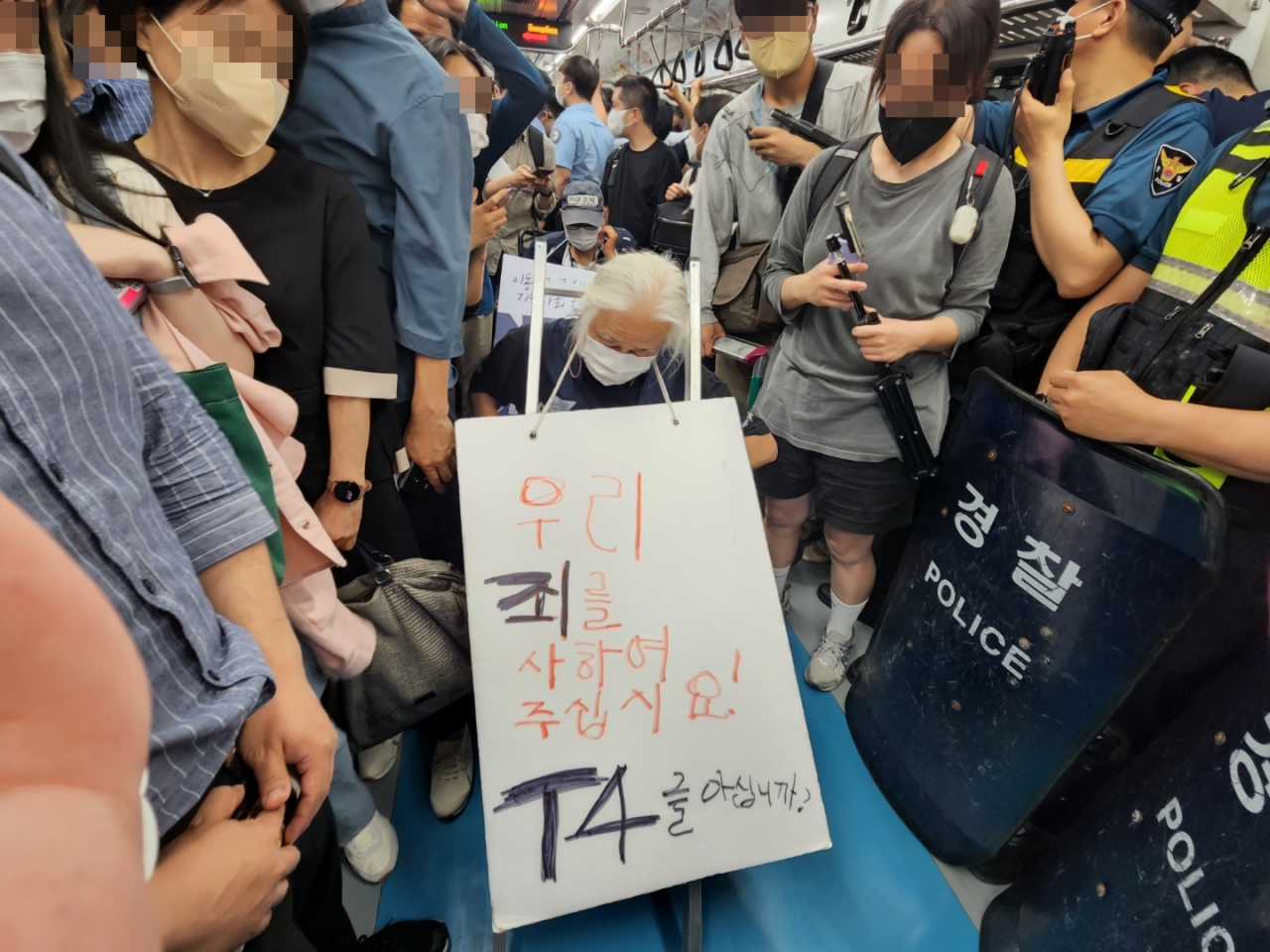 13일 오전 서울 지하철 4호선 서울역으로 향하는 열차에서 전국장애인차별철폐연대(전장연) 관계자들이 출근길 지하철 시위를 진행하는 모습. 박경석 전장연 상임공동대표가 목에 ‘우리의 죄를 사하여 주십시요! T4를 아십니까’라는 내용의 문구가 적힌 피켓을 걸고 있다. 권제인 수습기자