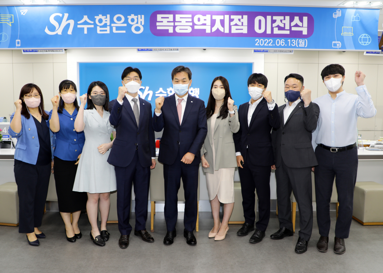 Sh수협은행 목동역지점이 지하철 5호선 목동역 8번 출구 앞 보성팰리스로 이전했다. 13일 이전 기념행사에서 김진균 은행장(가운데)과 신민수 목동역지점장(왼쪽 네 번째), 지점 직원들이 함께 기념촬영을 하고 있다.[Sh수협은행 제공]
