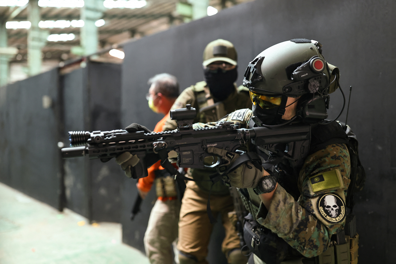 Trainees prepare to enter a building with their airsoft guns during an airsoft gun shooting lesson at the shooting range of the combat skill training company Polar Light, in New Taipei City, Taiwan, May 22, 2022. Since the war in Ukraine started three months ago, bookings have nearly quadrupled for lessons in how to shoot airsoft guns, or low-power devices designed to shoot non-metallic projectiles.조 바이든 미국 행정부가 대만에 무기를 판매할 때 중국군의 상륙 저지에 효과적인 품목의 판매를 가장 우선시하는 것으로 알려졌다. 미 국방부 고관은 올해 봄 미국·대만 비즈니스 평의회와 가진 회의에서 ‘비대칭 무기’의 판매를 한층 우선한다는 방침을 강조했다. 사진은 지난달 22일 대만 신베이(新北)에서 에어소프트건으로 훈련하는 대만 시민. [로이터]