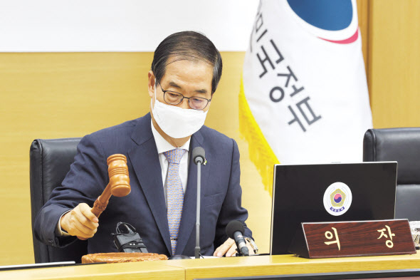 한덕수 국무총리가 14일 오전 정부세종청사에서 서울과 영상으로 연결해 열린 국무회의에서 의사봉을 두드리고 있다. 한 총리는 국무회의 직후 브리핑을 통해 규제혁신이 곧 국가성장이라며 민간 전문가로 구성된 규제심판관을 신설하고 정부 규제혁신의 최고 결정기구로서 규제혁신전략회의를 신설하는 등의 ‘새 정부 규제혁신 추진방향’을 발표했다. [연합]