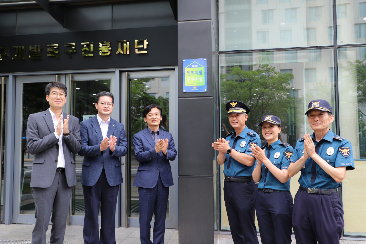 연구개발특구진흥재단 사옥에 범죄예방 우수시설 인증패를 부착한 모습. 왼쪽부터 김대현 특구진흥재단 안전관리팀장, 김인신 경영지원본부장, 강병삼 이사장, 임운택 유성경찰서 생활안전과장, 김주연 생활안전계장, 신정식 도룡지구대장.[연구개발특구진흥재단 제공]