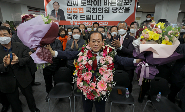 '50억 클럽' 논란으로 공석이 된 대구 중남에 무소속으로 출마해 당선이 확정된 임병헌 의원이 축하 꽃다발을 목에 걸고 기념 사진을 찍고 있다. 국민의힘은 지선이 끝난 2주뒤 임 의원의 복당을 허용했다. 임 의원은 14일 의원총회에서 국민의힘 의원들의 박수속에 복당했다. [연합]