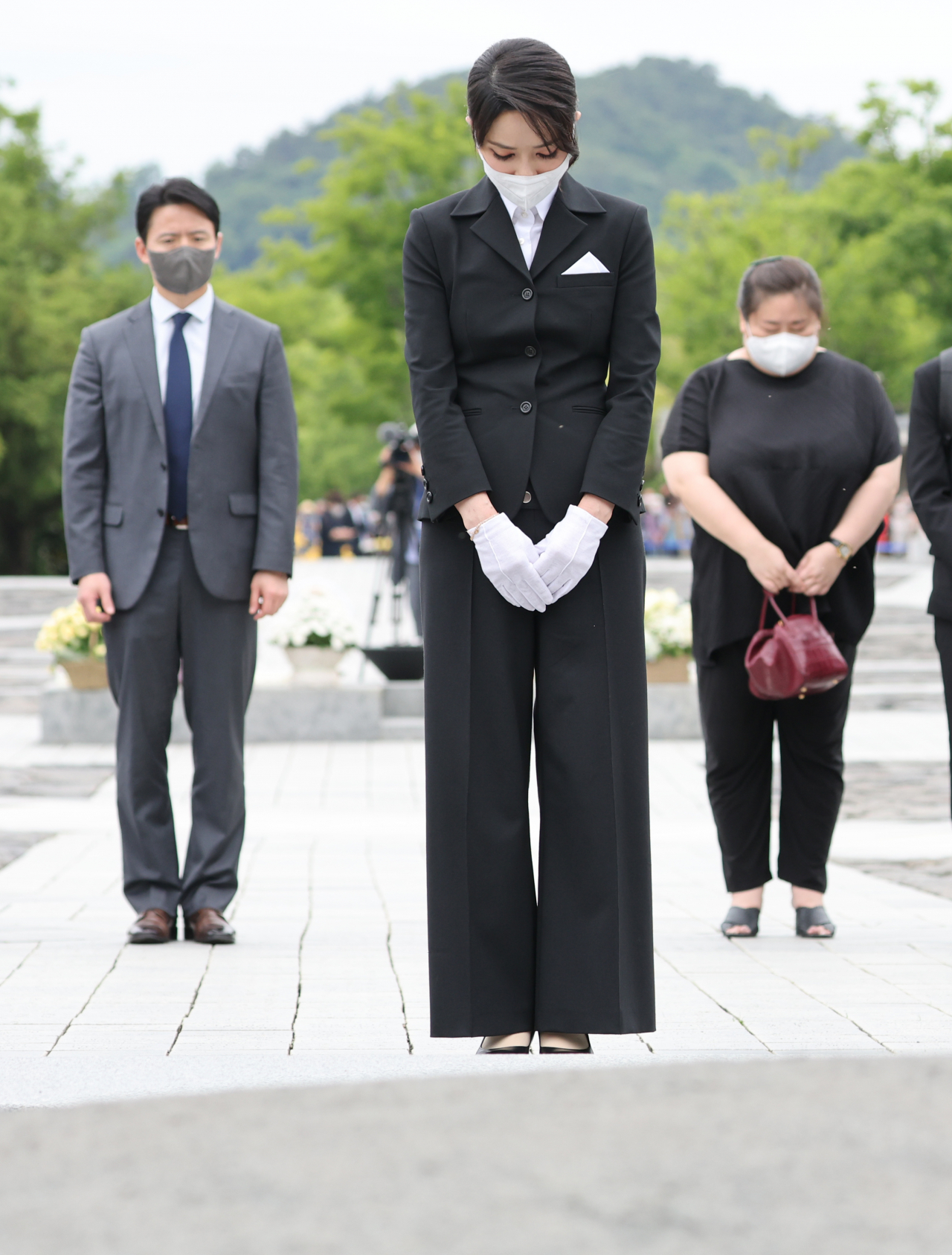 윤석열 대통령의 배우자 김건희 여사가 13일 오후 경남 김해시 진영읍 봉하마을을 방문해 고(故) 노무현 전 대통령 묘역을 참배하고 있다. 오른쪽 뒤에 서있는 인물이 김 여사의 지인인 충남대 김모 교수다. [연합]