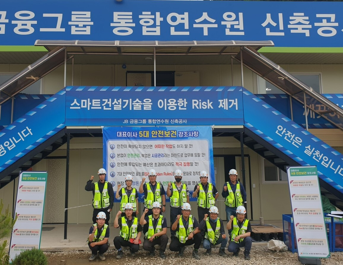 동부건설 직원들이 DB금융그룹 통합연수원 신축공사 현장에 설치된 대표이사 5대 안전보건 강조사항 현수막 앞에서 기념촬영을 하고 있다. [동부건설 제공]