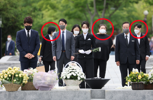 윤석열 대통령 부인 김건희 여사가 13일 오후 경남 김해시 진영읍 봉하마을을 방문해 고(故) 노무현 전 대통령 묘소에 헌화하고 있다. 김 여사 뒷줄 가운데 검은색 티셔츠를 입은 여성과 양끝 가방을 든 여성 2명(사진 속 동그라미)이 코바나컨텐츠 직원 출신인 것으로 드러났다. [연합]