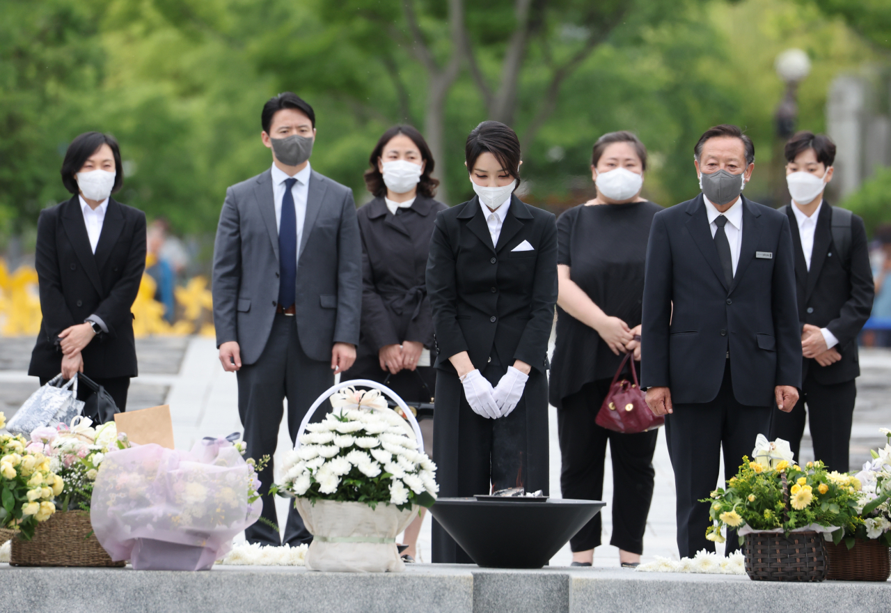 윤석열 대통령 부인 김건희 여사가 13일 오후 경남 김해시 진영읍 봉하마을을 방문해 고(故) 노무현 전 대통령 묘소에 헌화하고 있다. 김 여사 뒷줄 가운데 검은색 티셔츠를 입은 여성과 양끝 가방을 든 여성 2명이 코바나컨텐츠 직원 출신인 것으로 드러났다. [연합]