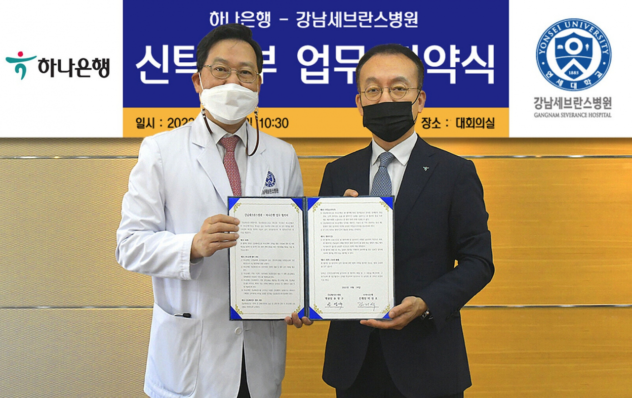 업무협약식에 참석한 김기석 하나은행 자산관리그룹 부행장(사진 오른쪽)과 송영구 연세대 강남세브란스 병원장(사진 왼쪽)이 기념 촬영을 하고 있다.